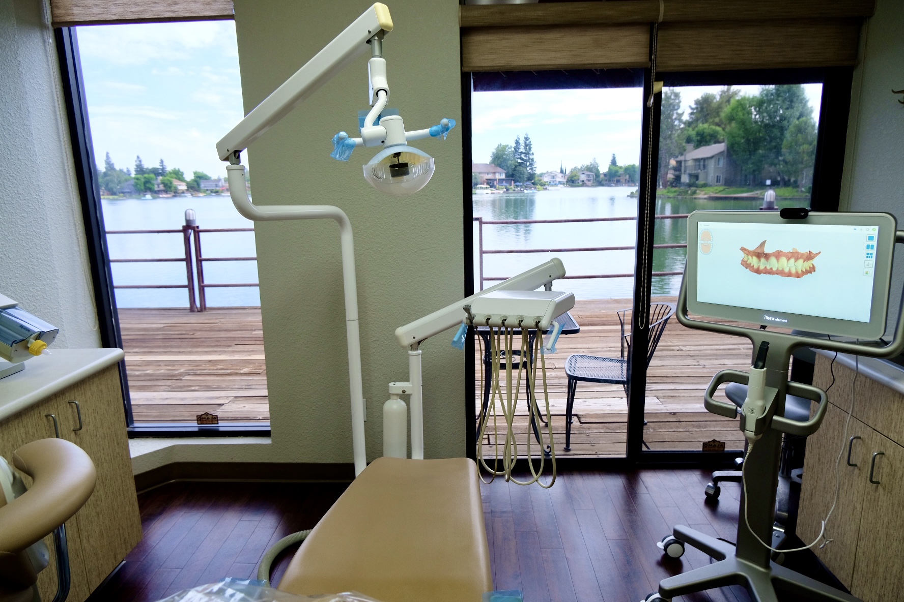 Treatment room with a large window overlooking the lake and a chairside monitor